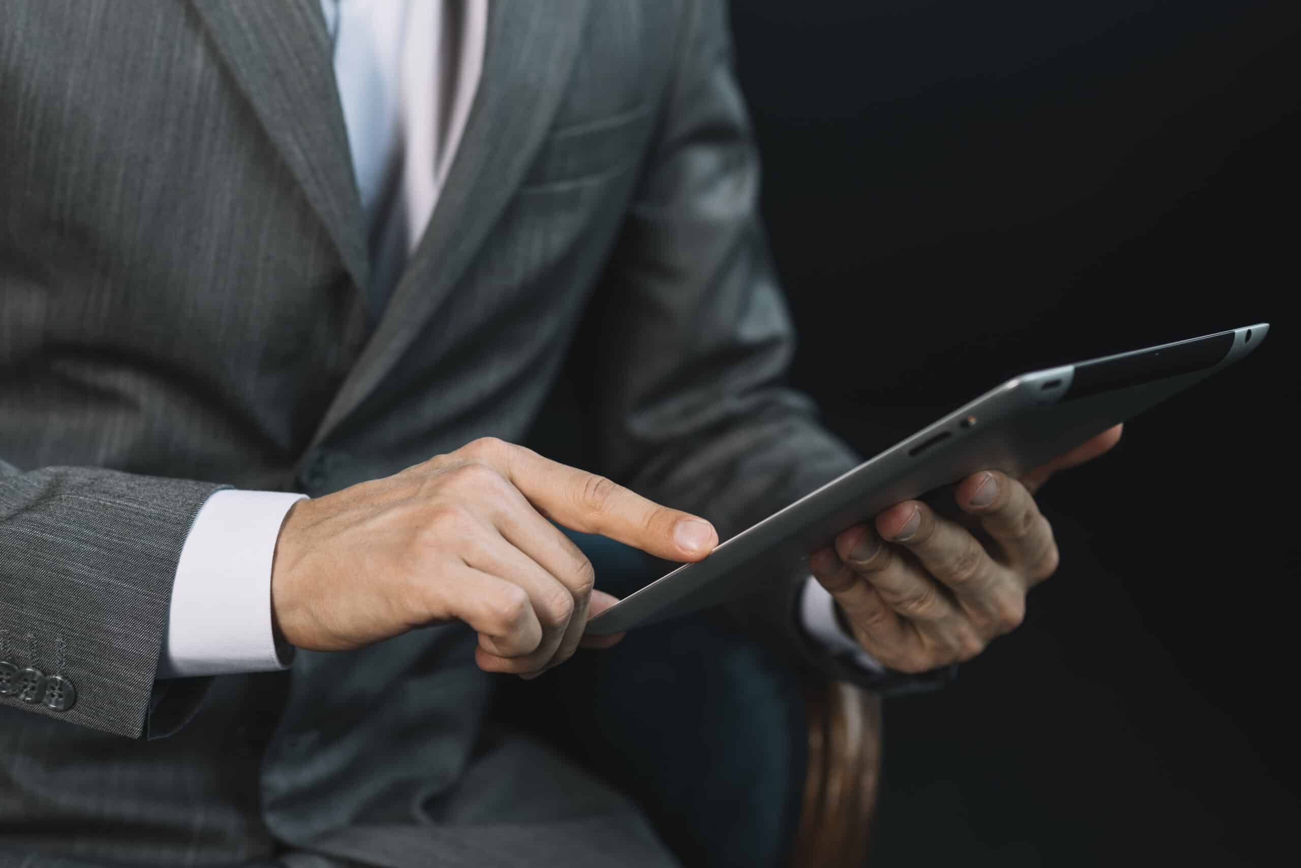 close-up-businessman-s-hand-touching-digital-tablet-screen